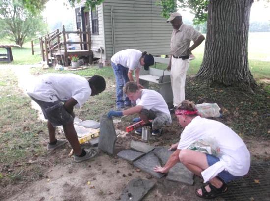 Trappe Summer Youth Program participants (left to right) Brian Watson, Emily Baynard, John McGarry, and Kathy Kemp, supervisor, working on a stone walkway at the Trappe Rural Life 