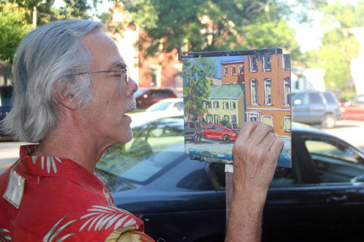 Artist Dennis Young works on a street scene. 