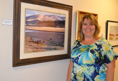 Jennifer Dyott, CRNP, of the Comprehensive Breast Center team, stands with her original photograph, “Where the Buffalo Roam,” which is featured in the Center’s summer art exhibit.